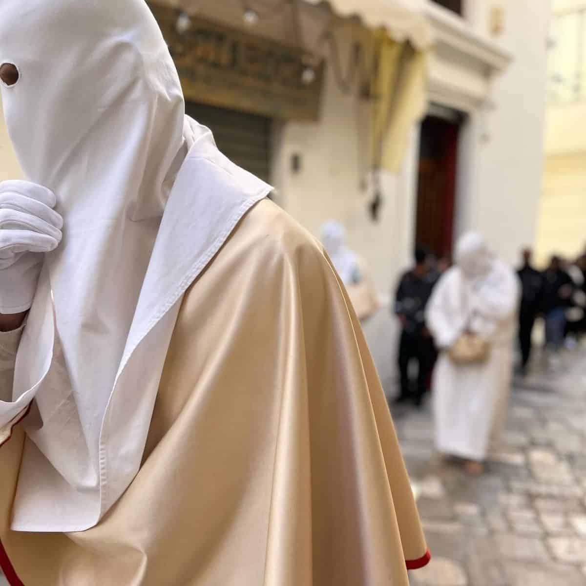 Confratelli della Purita con cappuccio bianco e manto giallo paglierino durante la processione della Desolata a Gallipoli