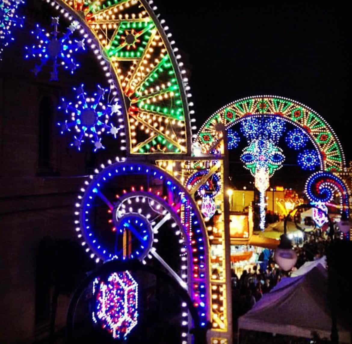 Dettaglio delle luminarie colorate con decorazioni a stella e spirale a Parabita